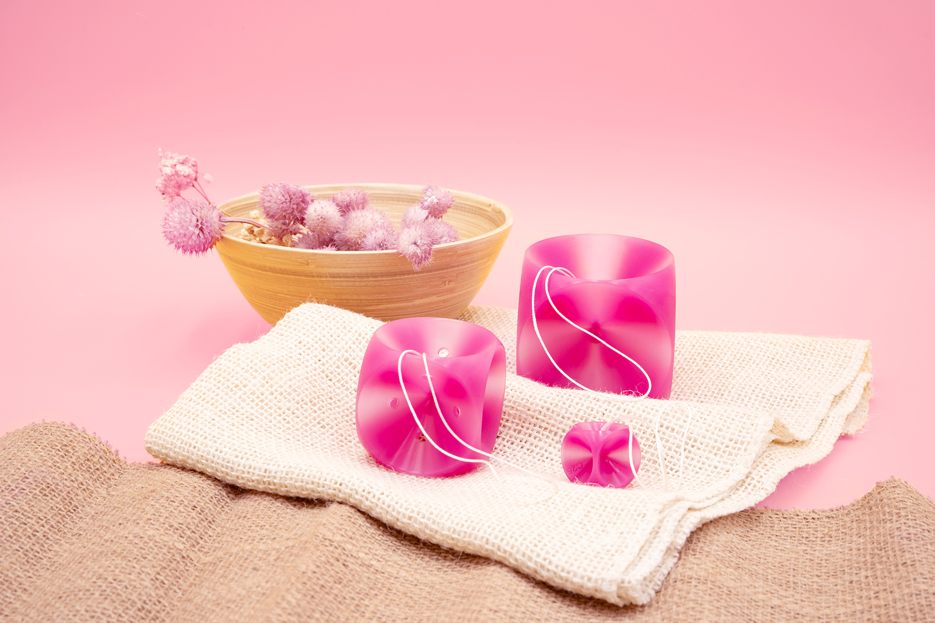 Verschiedene femicare Würfel-Pessare sind dekorativ auf einem Tuch abgebildet.